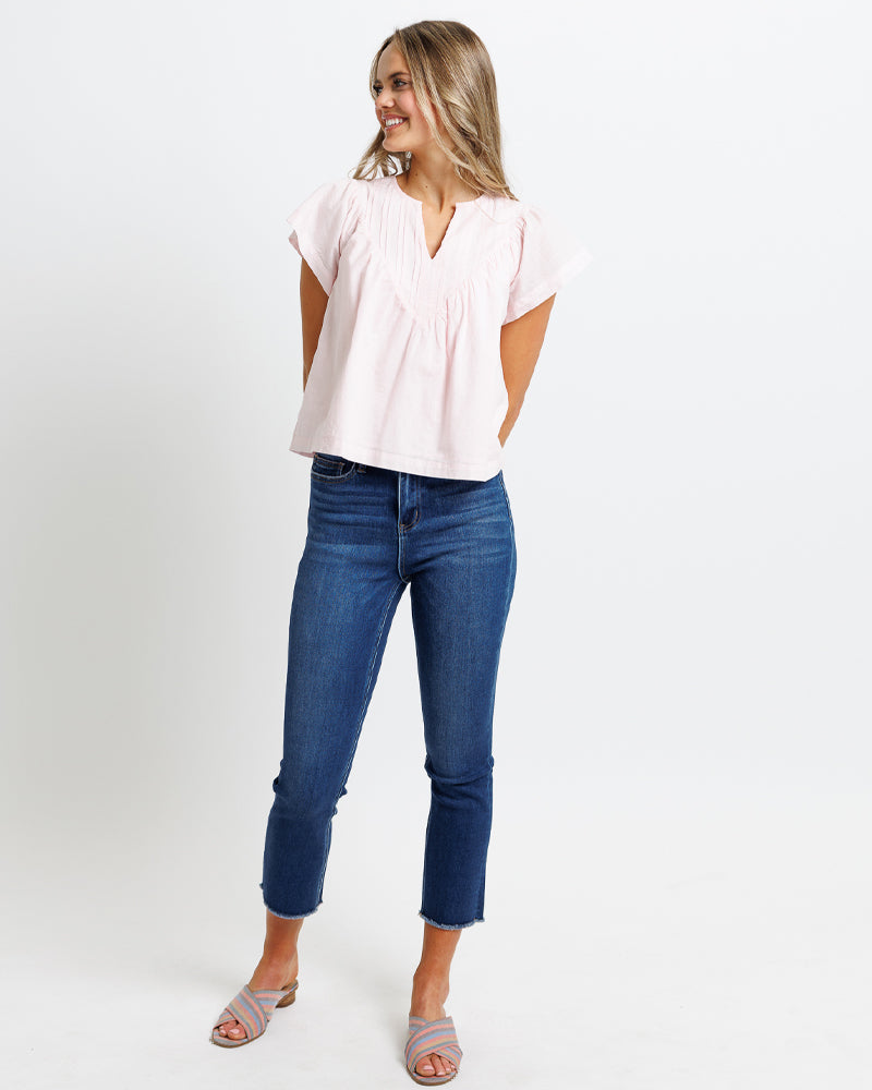 Wearing wearing dark blue high rise cropped stretch denim jeans.