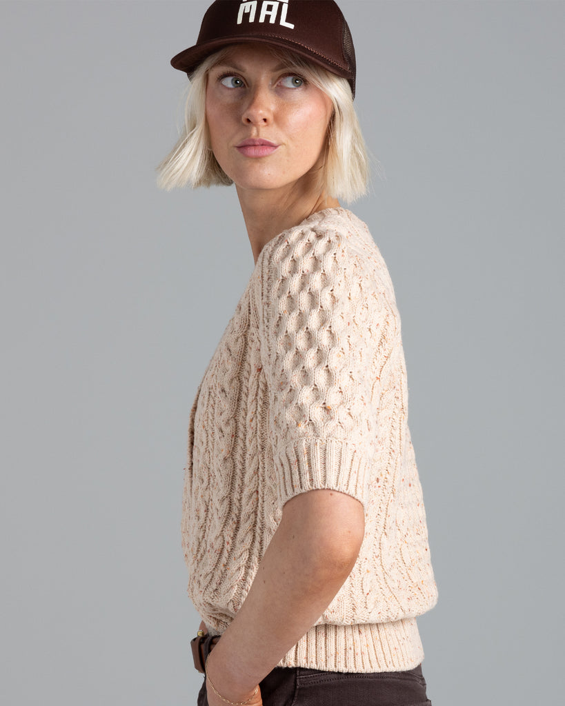 Model wearing a beige short sleeve v-neck cardigan.