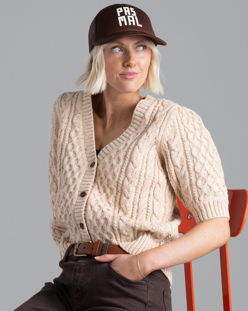 Model wearing a beige short sleeve v-neck cardigan.