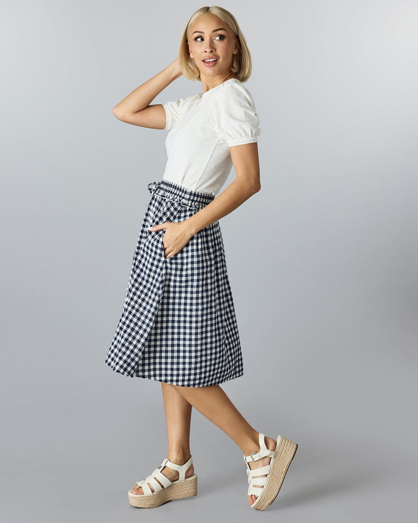 Woman in a gingham, midi-length skirt.