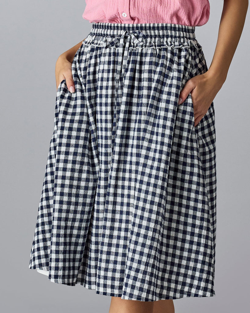 Woman in a gingham, midi-length skirt.