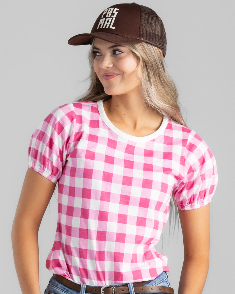 Model wearing a bright pink and white gingham print short sleeve t-shirt.