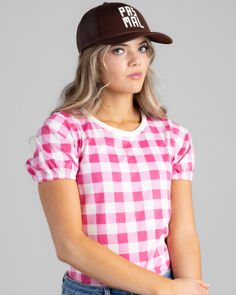 Model wearing a bright pink and white gingham print short sleeve t-shirt.