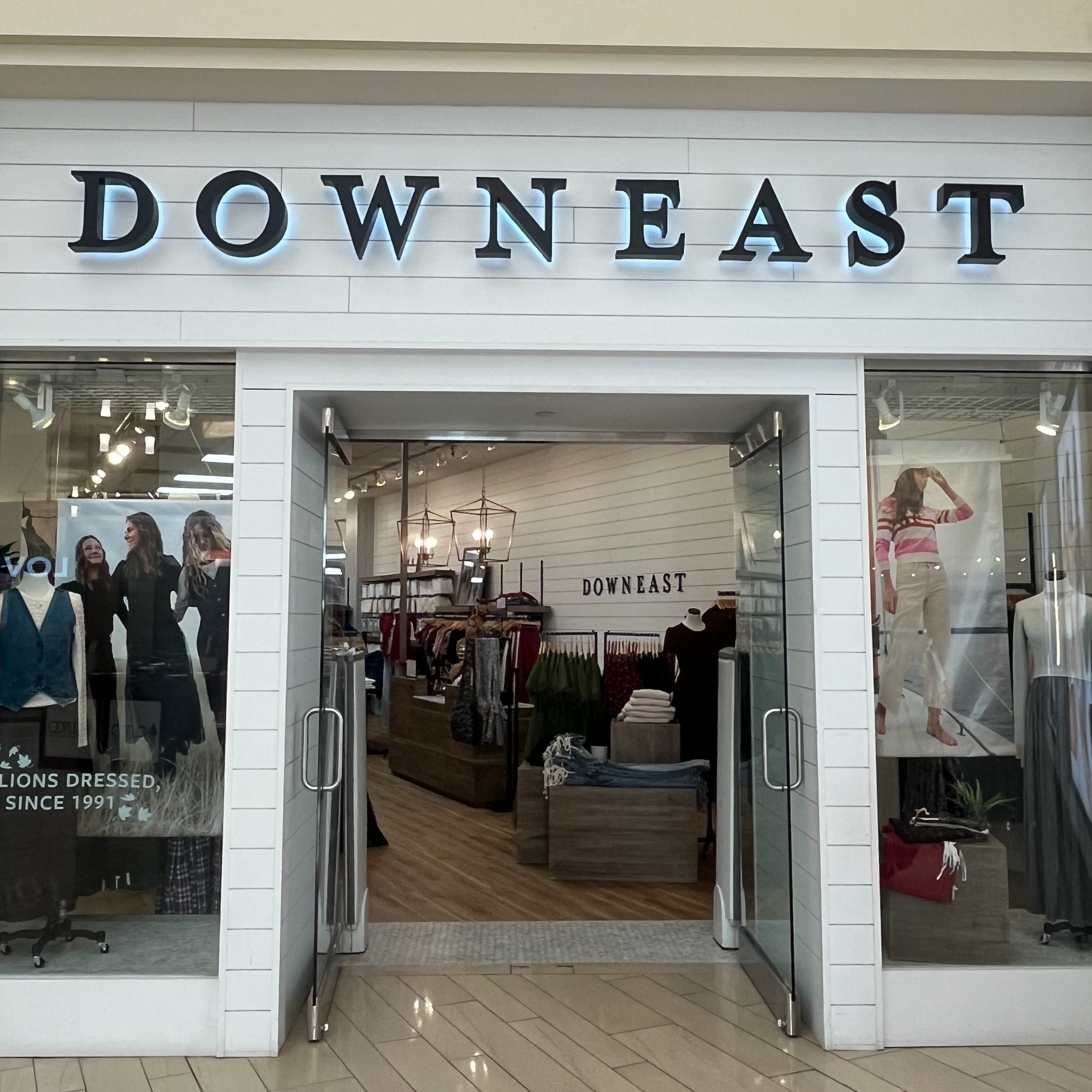 Storefront of Downeast clothing store with glass doors and interior display.