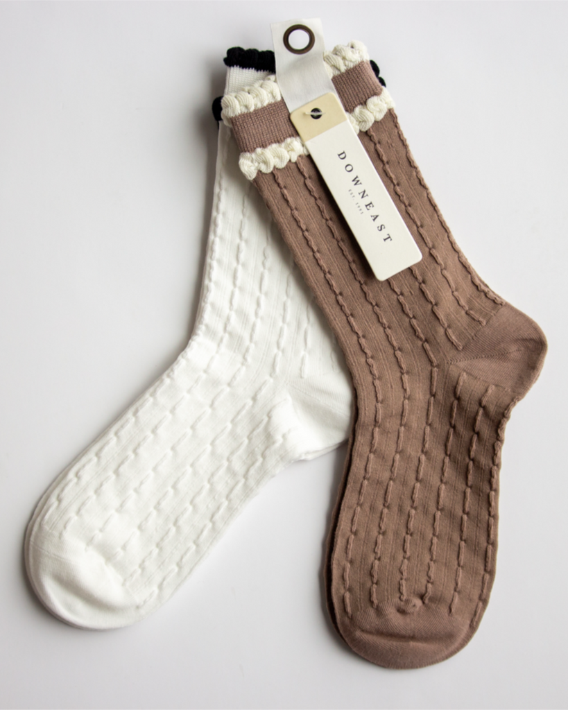 Pair of brown and white socks with a visible brand tag on a light gray background