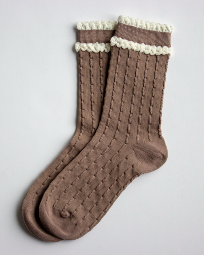 Pair of brown socks with white trim on a light gray background