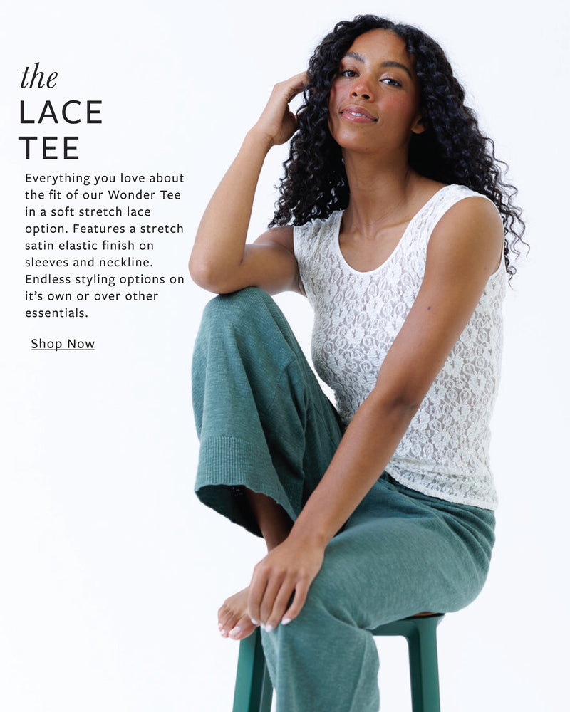Woman wearing a white lace top and green pants sitting on a white background with promotional text about the lace tee.
