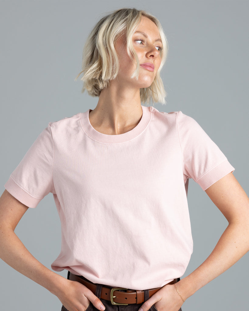 Model wearing a light pink, short sleeve basic tshirt.