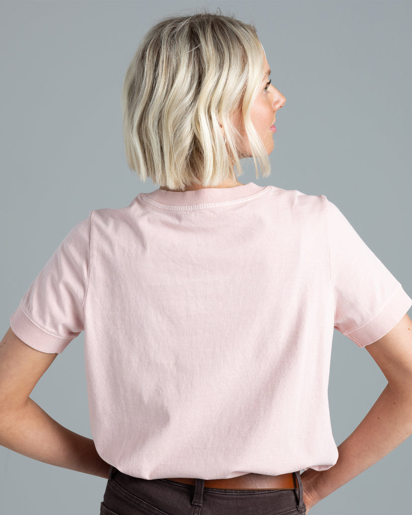 Model wearing a light pink, short sleeve basic tshirt.